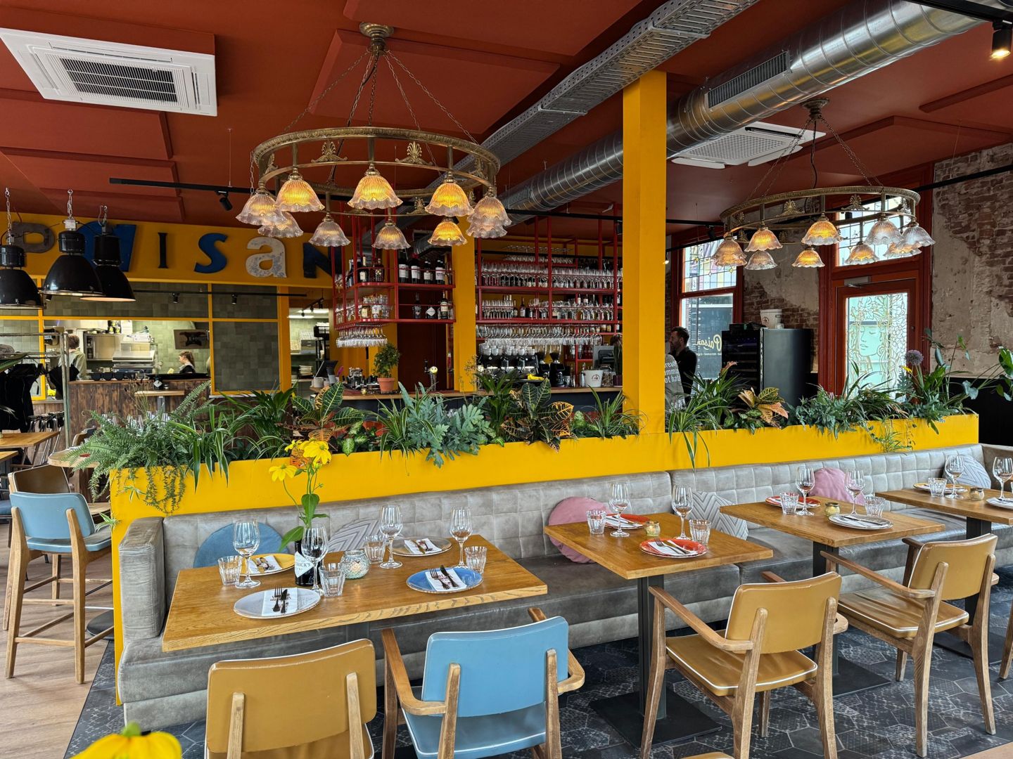Het restaurant van Paisan nu: oranje plafond, gele plantenbak en kroonluchters