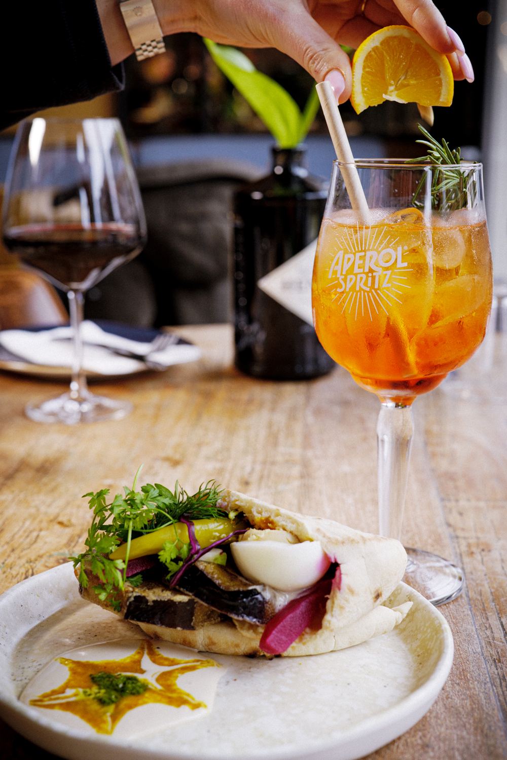 Een Aperol Spritz naast een gevulde pita